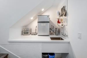 a white kitchen with a refrigerator and a sink at Sweet Escape in San Diego