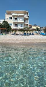 un edificio en la playa con aguas cristalinas en Magic Ionian Apartments & Rooms, en Himare