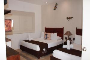 a bedroom with two beds and butterflies on the wall at Villas Palmar Holbox in Holbox Island