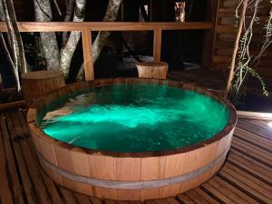 Illi Lodge & Hostel في Ranco: حوض خشبي مليء بالماء على سطح خشبي