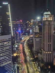 eine Skyline der Stadt bei Nacht mit Verkehr auf einer Autobahn in der Unterkunft Luxury, Modern & Spacious Two Bedrooms Fully Furnished Apartment in Jakarta