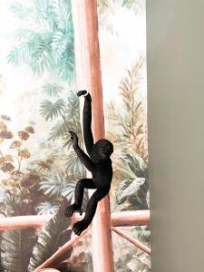 un mono negro colgando de una pared con un mural en Studio Jungle Ludres, en Ludres