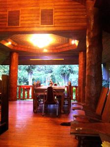 ein Esszimmer mit einem Tisch und Stühlen auf einem Holzboden in der Unterkunft Samnaree Garden House in Ban Phae Mai
