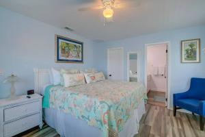 a blue bedroom with a bed and a blue chair at Direct gulf access with boat dock minutes from Weechi Wachee in Hernando Beach