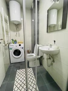 a bathroom with a washing machine and a sink at Tower apartment in Prishtinë