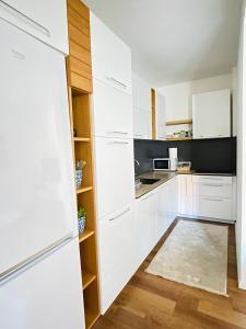 a kitchen with white cabinets and a refrigerator at Tower apartment in Prishtinë