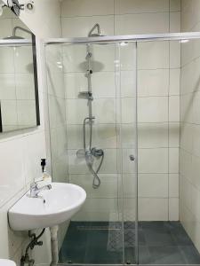 a bathroom with a glass shower and a sink at Tower apartment in Pristina