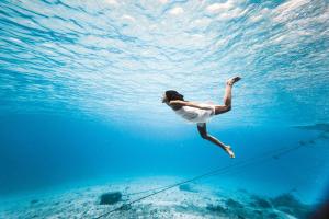 una mujer está nadando en el agua en Hotel B Cozumel, en Cozumel