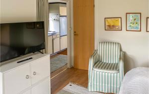 een woonkamer met een flatscreen-tv en een stoel bij Awesome Home In Falkenberg With Wifi in Falkenberg