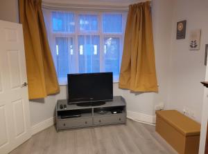 ein Wohnzimmer mit einem Flachbild-TV auf einem Stand in der Unterkunft Golden Square Place in Warrington