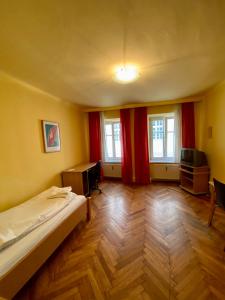 a bedroom with a bed and a desk and two windows at Appartement Pension 700m zum Ring in Vienna