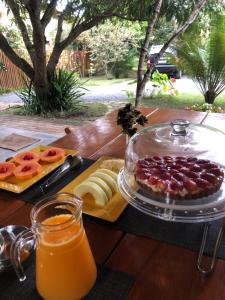 una mesa con una bandeja de comida y zumo de naranja en Pousada Pomar dos Campos en Vale do Capao