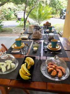 a wooden table with plates of food on it at Pousada Pomar dos Campos in Vale do Capao