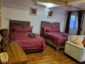 a bedroom with two beds and a couch at Suci's Friendly Appartment in Mataram