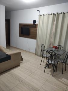 a dining room with a table and chairs and a television at APTO EM CONDOMÍNIO FECHADO ( B1-304) in Rio Verde