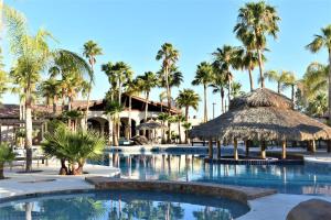 a pool at a resort with palm trees at HACIENDA MONARCAS Resort in Puerto Peñasco