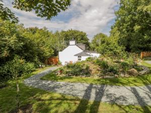 a garden with a white house in the background at Carreg Winllan in Amlwch
