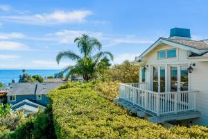 een wit huis met een balkon en de oceaan bij Golden Getaway in Summerland