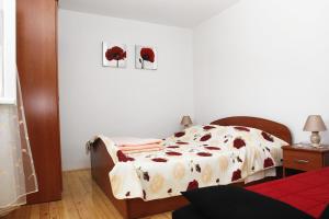 a bedroom with a bed with a blanket on it at Apartments by the sea Korcula - 6016 in Korčula