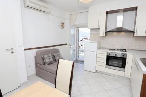 a kitchen with white cabinets and a couch in it at Apartments by the sea Korcula - 6016 in Korčula