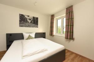 a bedroom with a bed and a window at Hotel Am Gleis 1 in Sonthofen