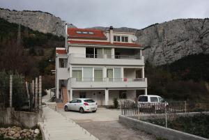 una casa con due macchine parcheggiate di fronte di Apartments with a swimming pool Zakucac, Omis - 5954 a Omiš (Almissa)