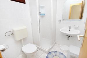 a white bathroom with a toilet and a sink at Apartments by the sea Vinisce, Trogir - 5982 in Vinišće