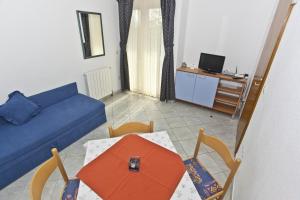 a living room with a couch and a table and chairs at Apartments and rooms by the sea Brela, Makarska - 6056 in Brela