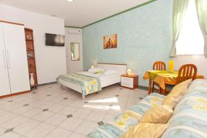 a bedroom with two beds and a table and chairs at Apartments and rooms by the sea Brela, Makarska - 6056 in Brela