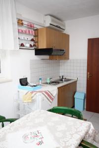 cocina con mesa, fregadero y encimera en Apartments with a parking space Supetar, Brac - 6036, en Supetar