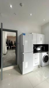a white kitchen with a refrigerator and a microwave at Luxury 2 Bed Duplex Apartment by YO ROOM! - Leicester City- Free Parking in Leicester