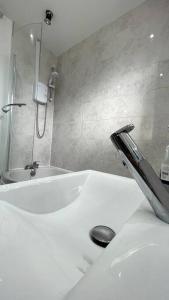 uma casa de banho branca com um chuveiro e um lavatório. em Luxury 2 Bed Duplex Apartment by YO ROOM! - Leicester City- Free Parking em Leicester