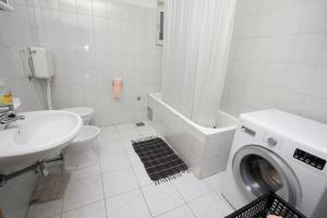 a bathroom with a washing machine and a sink at Apartment Baska Voda 6057c in Baška Voda