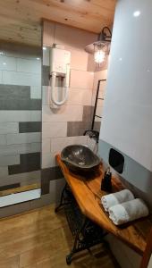 y baño con lavabo sobre una mesa de madera. en Къща за гости Каза Роза - Swiss Style Chalet Casa Rosa Guest House en Kyustendil