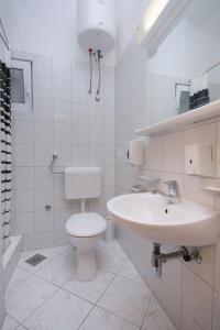 a white bathroom with a toilet and a sink at Apartment Pisak 5975d in Pisak
