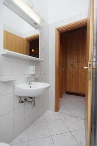 a bathroom with a sink and a wooden door at Apartment Pisak 5975d in Pisak