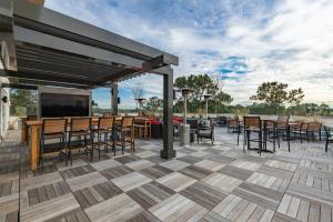 a patio with tables and chairs and a flat screen tv at Hotel Spice & Sky Atlanta Perimeter in Atlanta