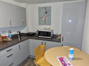 a small kitchen with a table and a microwave at 26 Lindhurst Way West in Mansfield