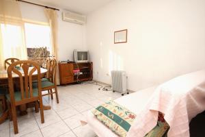 una camera con tavolo, letto e TV di Apartments by the sea Kastel Stari, Kastela - 6059 a Kaštela (Castelli)