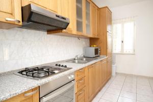 una cucina con piano cottura, lavello e forno a microonde di Apartments by the sea Kastel Stari, Kastela - 6059 a Kaštela (Castelli)
