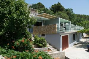 a house with a balcony and trees at Apartment Lokva Rogoznica 6005a in Lokva Rogoznica