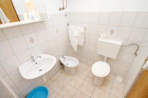 uma casa de banho branca com um WC e um lavatório em Apartment Lokva Rogoznica 6005a em Lokva Rogoznica