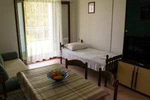 a living room with two beds and a table with a bowl of fruit at Apartment Lokva Rogoznica 6005a in Lokva Rogoznica
