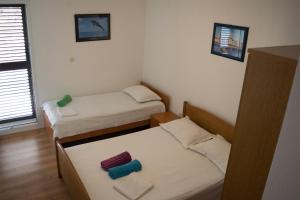 ロクヴァ・ロゴズニツァにあるApartments by the sea Lokva Rogoznica, Omis - 6005のベッドが2つと窓がある小さな部屋