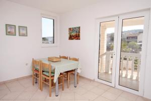a dining room with a table and chairs and a balcony at Apartments with parking space Slatine, Ciovo - 6061 in Slatine