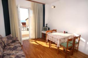 a dining room with a table and chairs and a window at Apartments with parking space Drasnice, Makarska - 6042 in Drasnice