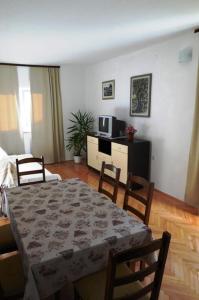 a living room with a table and chairs and a television at Apartments with parking space Drasnice, Makarska - 6042 in Drasnice