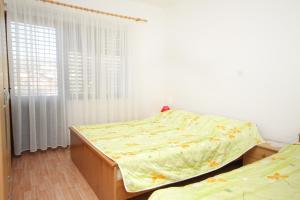 a bedroom with two beds and a window at Apartments with a parking space Seget Vranjica, Trogir - 5966 in Seget Vranjica