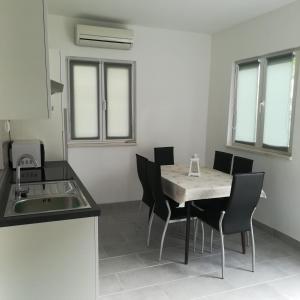 a kitchen and dining room with a table and chairs at Apartments with a parking space Seget Vranjica, Trogir - 5966 in Seget Vranjica