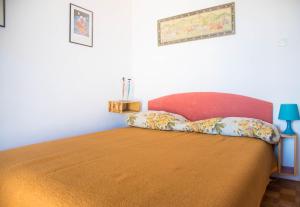 a bedroom with a bed with a red head board at Apartments with a parking space Postira, Brac - 6049 in Postira